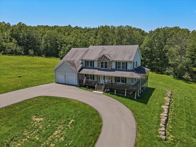 169 Roberts Rd, Starlight, PA 18461 - view of front of house featuring covered porch, a forest view, asphalt driveway, a front yard, and a garage