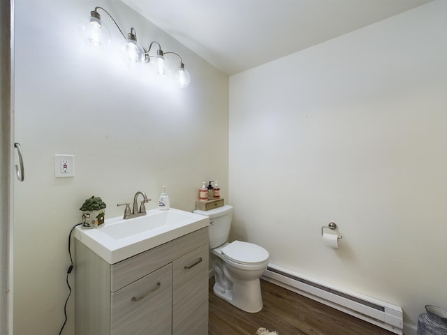 bathroom with a baseboard heating unit, vanity, toilet, and wood finished floors