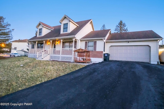 cape cod house featuring aphalt driveway, covered porch, an attached garage, and a front lawn