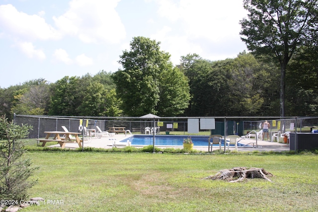 community pool featuring fence and a lawn