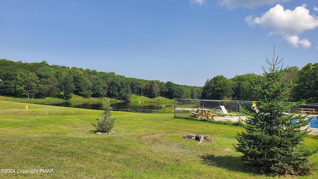 view of yard featuring a water view and a wooded view