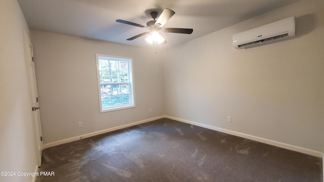 empty room with dark colored carpet, a wall mounted air conditioner, a ceiling fan, and baseboards