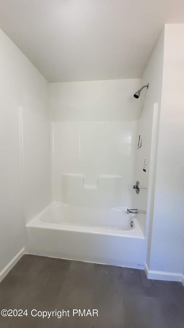 full bathroom featuring washtub / shower combination and baseboards