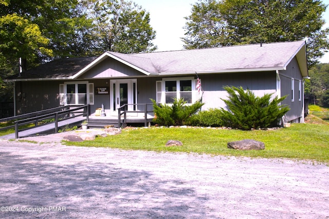 single story home featuring covered porch and a front lawn