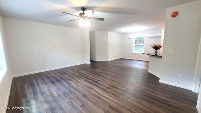 unfurnished room featuring dark wood-type flooring, ceiling fan, baseboards, and a wall mounted AC