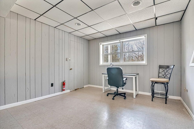 office area with wooden walls and tile patterned floors