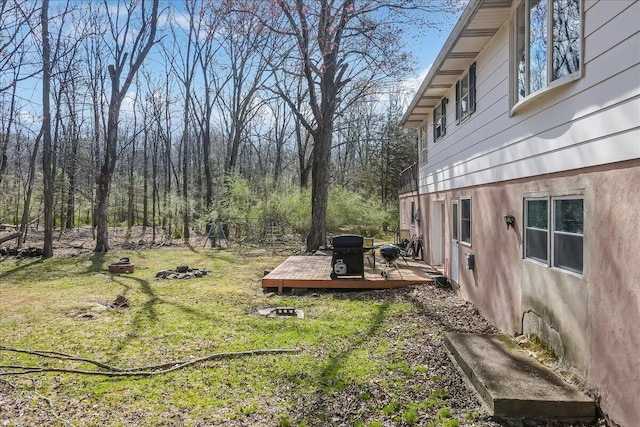 view of green lawn featuring a deck