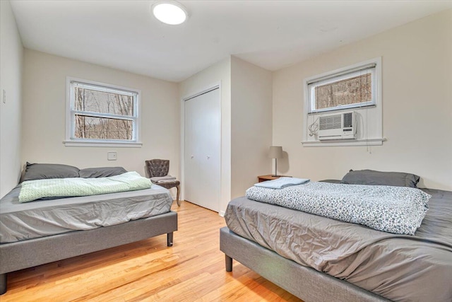 bedroom with a closet, wood finished floors, and cooling unit
