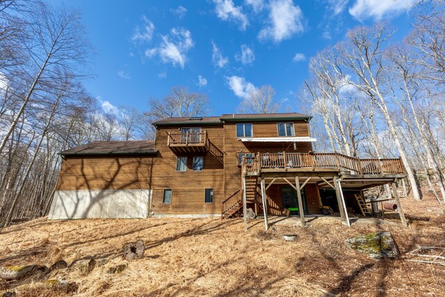 back of house featuring a wooden deck and stairs