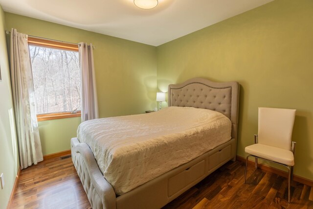 bedroom with dark wood-type flooring, visible vents, and baseboards