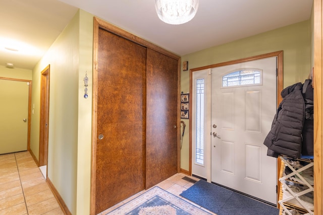 foyer featuring light tile patterned flooring and baseboards