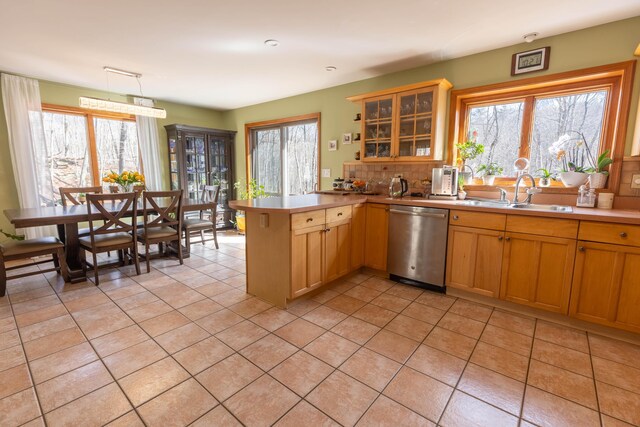 kitchen with a healthy amount of sunlight, a sink, a peninsula, and stainless steel dishwasher