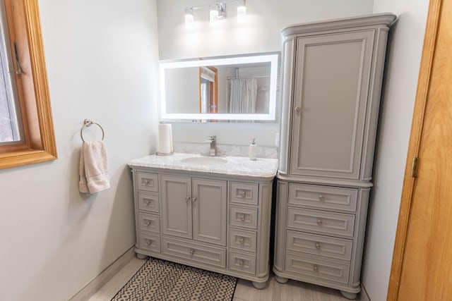 full bathroom featuring baseboards and vanity