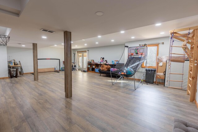 below grade area with recessed lighting, visible vents, baseboards, and wood finished floors