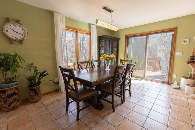 dining area featuring light tile patterned floors, baseboards, and a wealth of natural light