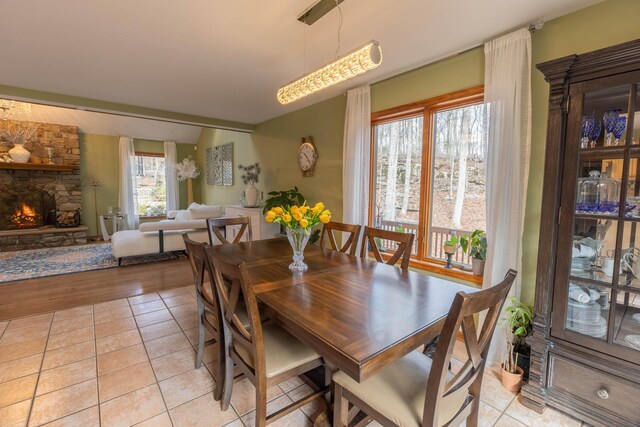 dining area featuring light tile patterned floors and a fireplace