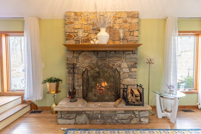 details featuring a fireplace, visible vents, and wood finished floors