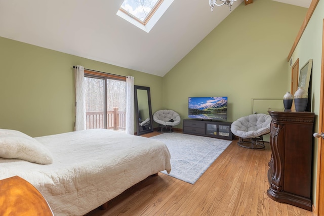 bedroom featuring high vaulted ceiling, a skylight, access to exterior, and light wood-style floors