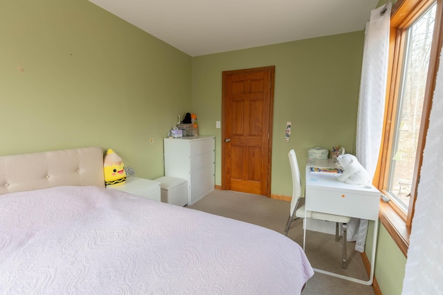 bedroom featuring carpet, multiple windows, and baseboards