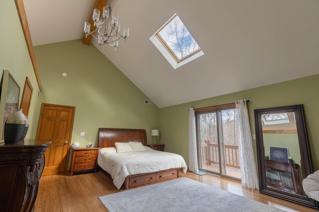 bedroom featuring a skylight, visible vents, access to outside, light wood finished floors, and beamed ceiling