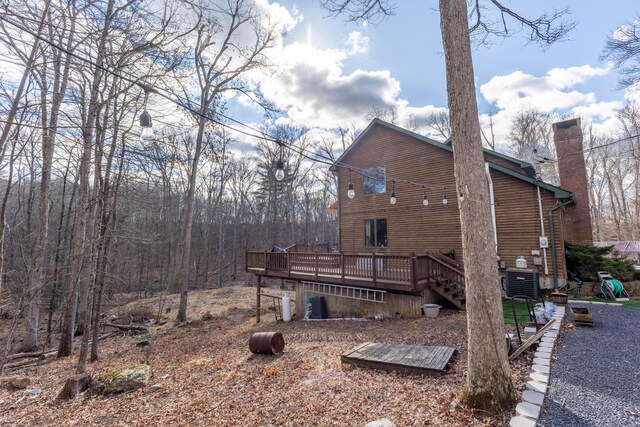 view of home's exterior featuring a chimney, a deck, and central AC unit