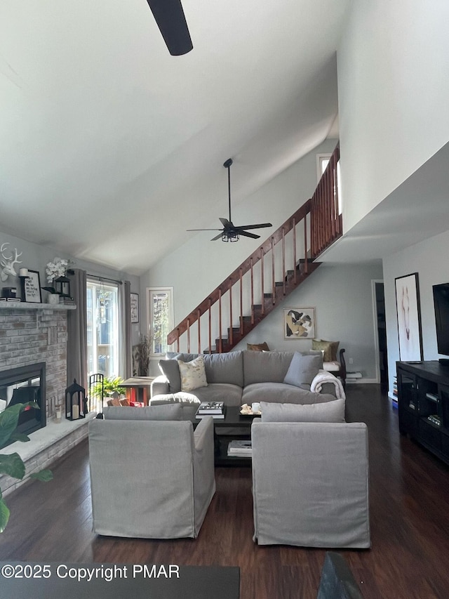 living area featuring stairway, high vaulted ceiling, a ceiling fan, and wood finished floors