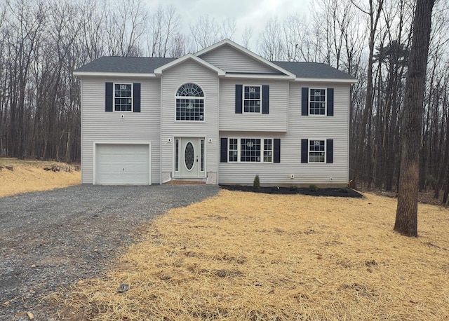 view of front of home featuring a garage, roof with shingles, and driveway