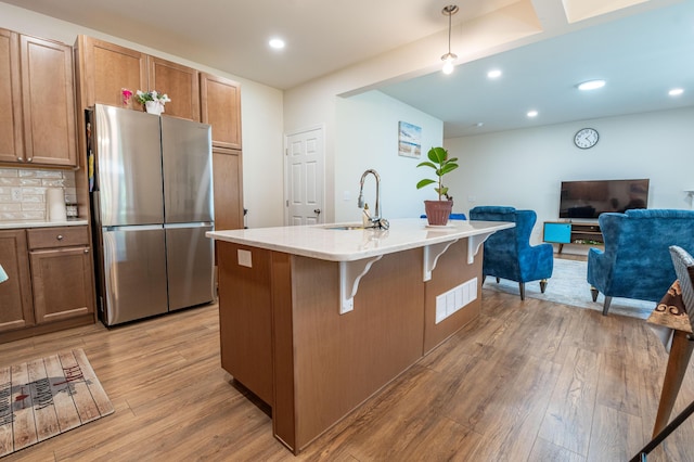 320 Bendelow Ln, Northampton, PA 18067 - kitchen with freestanding refrigerator, light wood finished floors, open floor plan, light countertops, and a kitchen breakfast bar