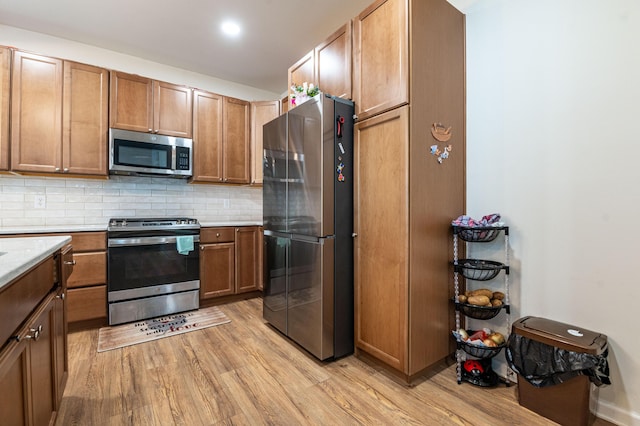 320 Bendelow Ln, Northampton, PA 18067 - kitchen with appliances with stainless steel finishes, light wood finished floors, light countertops, tasteful backsplash, and brown cabinetry