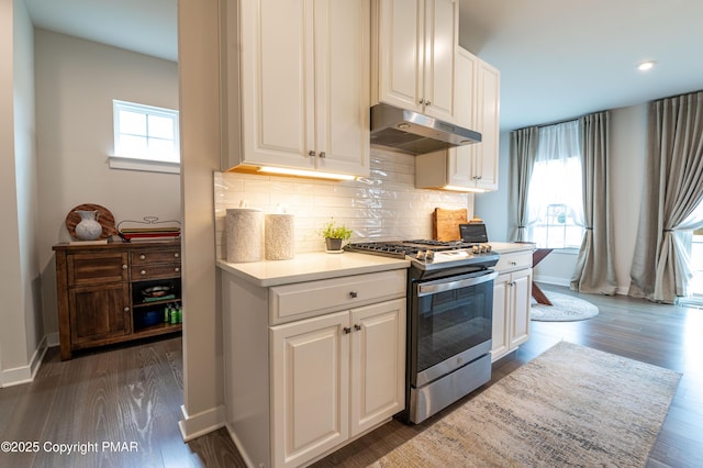 kitchen with white cabinetry, stainless steel range with gas stovetop, dark hardwood / wood-style flooring, and backsplash