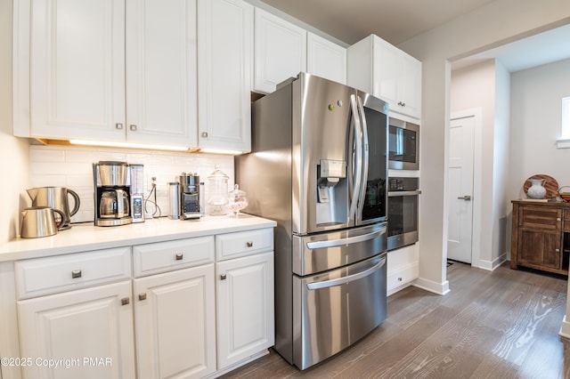 kitchen with white cabinetry, appliances with stainless steel finishes, dark wood-type flooring, and tasteful backsplash