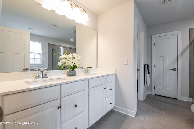 bathroom with an enclosed shower, vanity, and tile patterned flooring