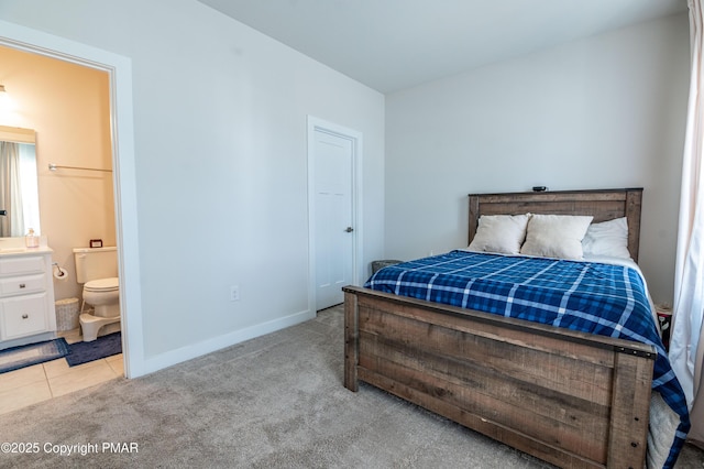 bedroom with light colored carpet and ensuite bathroom