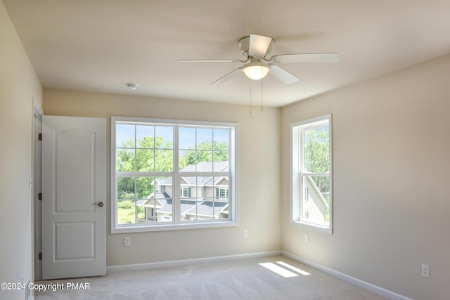 empty room featuring a ceiling fan, baseboards, and carpet flooring