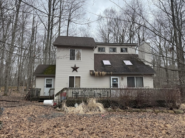 view of front of property featuring a wooden deck and a shingled roof