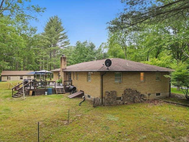 3106 Janet St, East Stroudsburg, PA 18301 - rear view of property featuring a deck, a chimney, a lawn, and brick siding