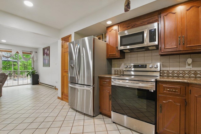 3106 Janet St, East Stroudsburg, PA 18301 - kitchen with stainless steel appliances, light tile patterned floors, decorative backsplash, brown cabinets, and a baseboard heating unit