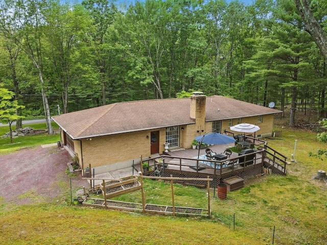 3106 Janet St, East Stroudsburg, PA 18301 - rear view of property featuring brick siding, a lawn, a wooden deck, a shingled roof, and a chimney