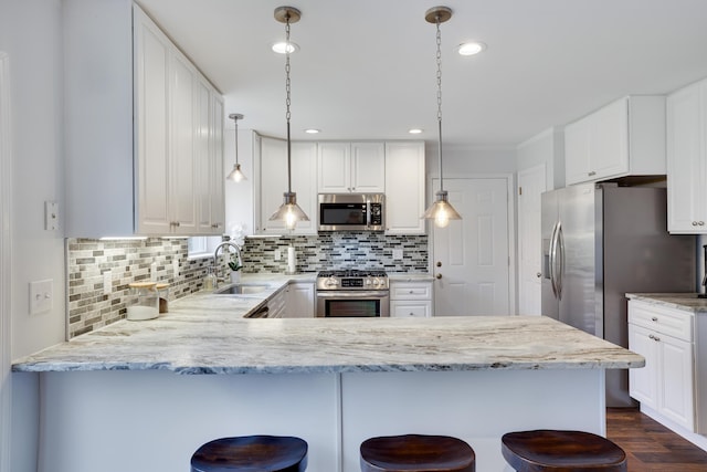 5175 White Birch Dr, Long Pond, PA 18334 - kitchen with stainless steel appliances, a sink, a peninsula, decorative backsplash, and white cabinetry