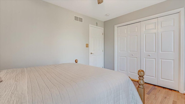 bedroom with visible vents, a closet, and light wood finished floors