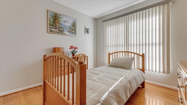 bedroom featuring hardwood / wood-style floors and baseboards