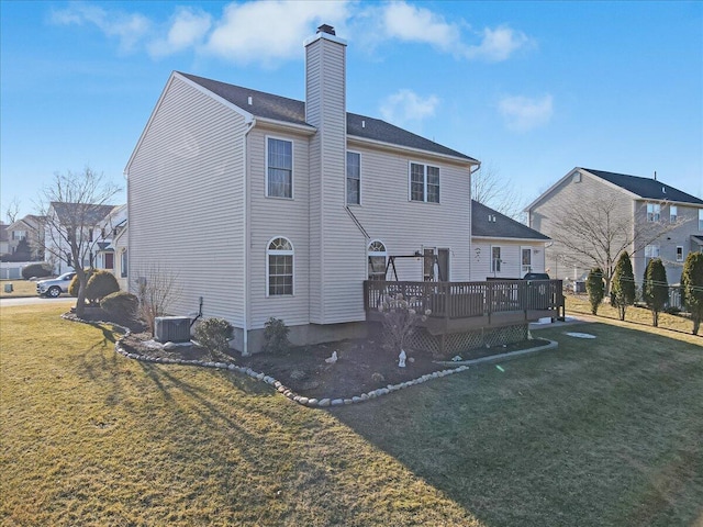 back of house with a chimney, a lawn, cooling unit, and a wooden deck