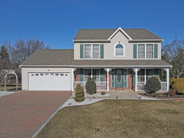 view of front of property featuring a porch, an attached garage, a front lawn, decorative driveway, and brick siding