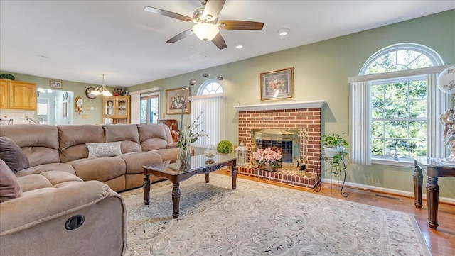 living area with light wood-style flooring, plenty of natural light, baseboards, and visible vents