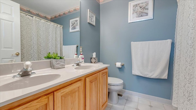 bathroom featuring tile patterned flooring, toilet, baseboards, and a sink