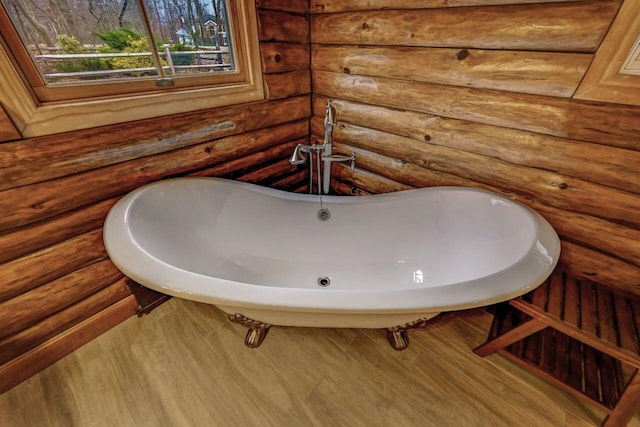 full bathroom featuring a freestanding tub and rustic walls