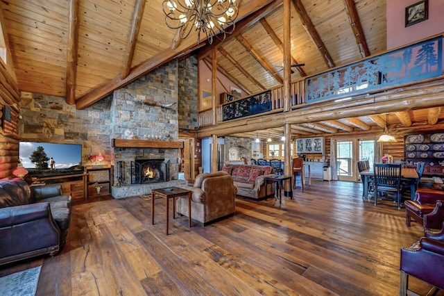 living room featuring an inviting chandelier, a stone fireplace, beamed ceiling, wood-type flooring, and high vaulted ceiling