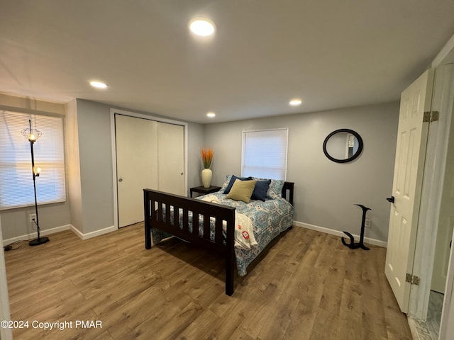 bedroom featuring recessed lighting, multiple windows, baseboards, and wood finished floors