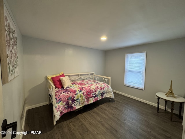 bedroom with dark wood-style floors and baseboards