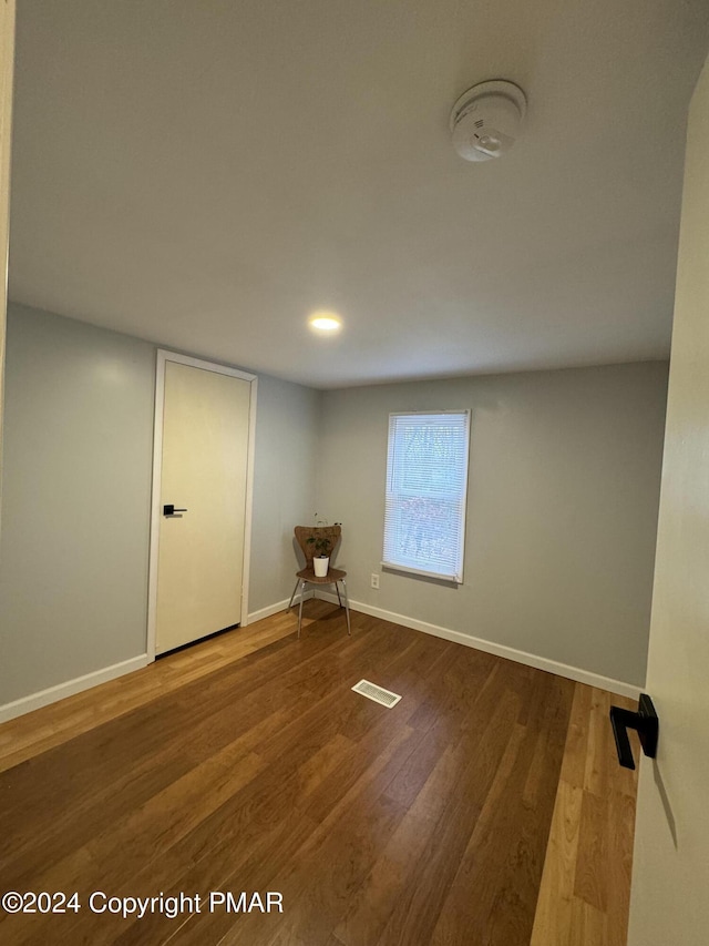 interior space with wood finished floors, visible vents, and baseboards